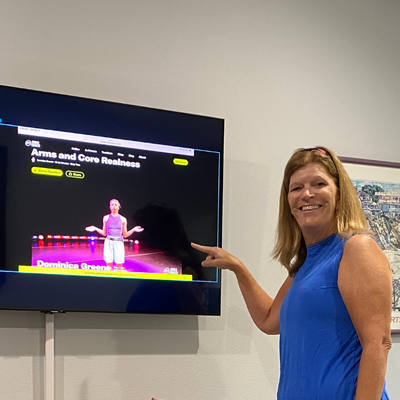 Woman stands in front of television pointing