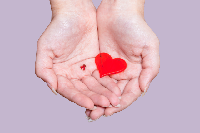 hands holding two heart designs
