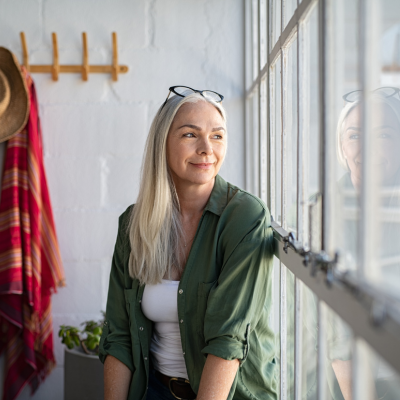 Mature woman looks out a window