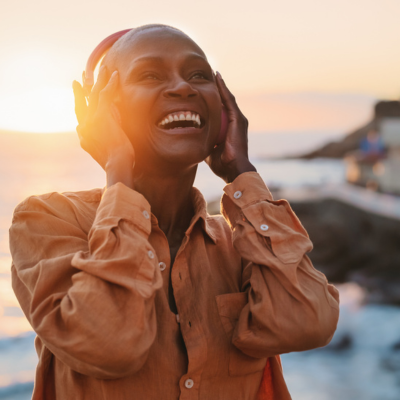 Beautiful sunset, woman listening to headphones, smiling