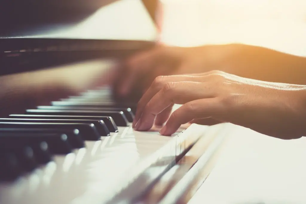 Close up of happy woman's hand playing the piano
