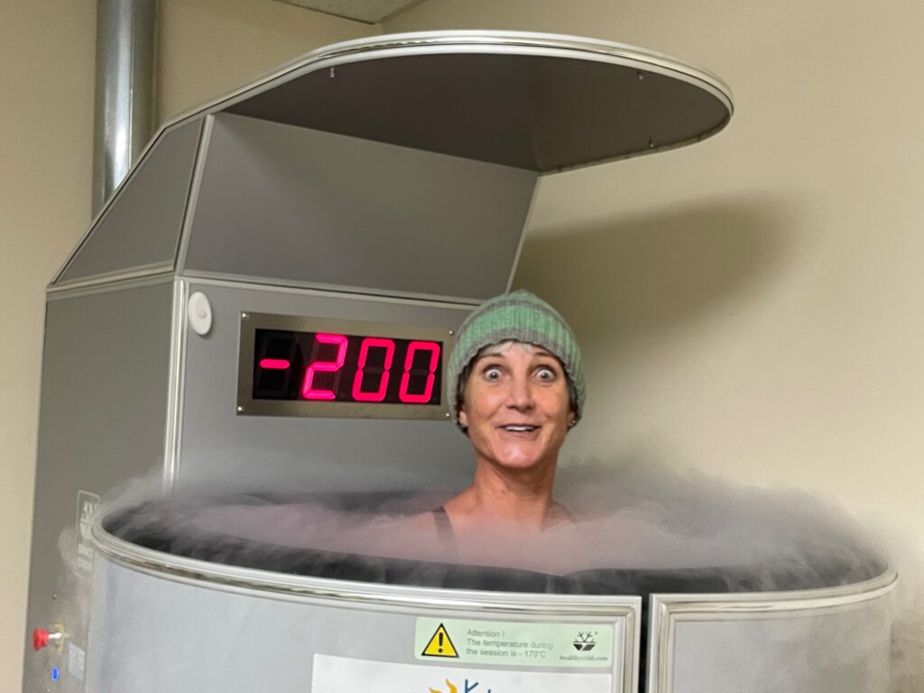 woman in cryo tank with green knit hat