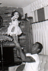 little girl is lifted up by her father