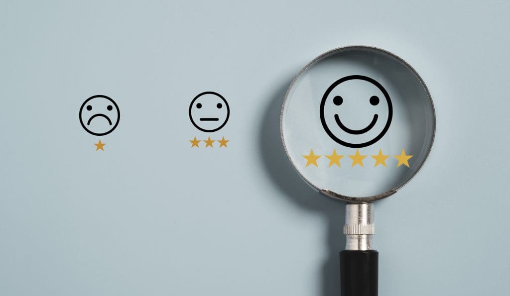 Smiley icon with five star inside magnifier glass on blue background