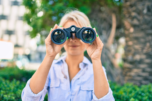 Woman peering thru binoculars