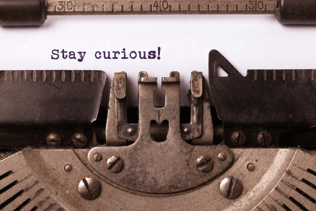 stay curious typed message in typewriter